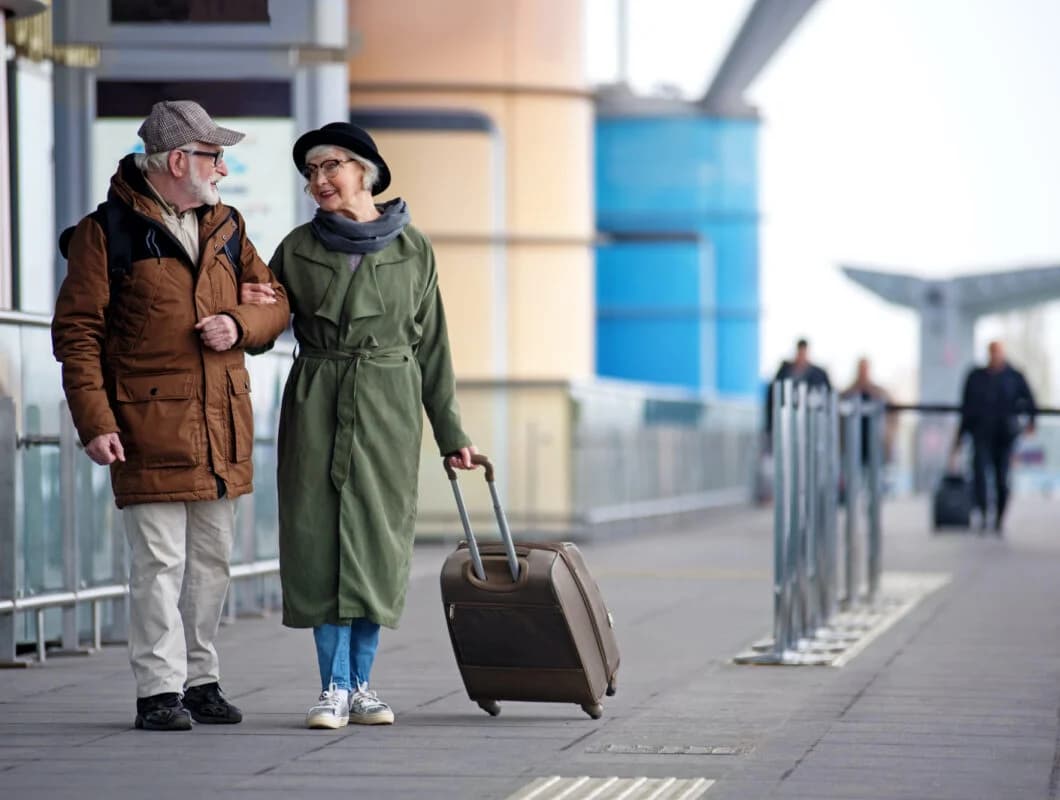 A travel companion walking with a passenger through an airport terminal